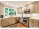 Well-lit kitchen featuring stainless steel appliances, including a dishwasher and gas range, complemented by a window with outside views at 6455 N Olney St, Indianapolis, IN 46220