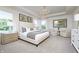 Bright primary bedroom features a chandelier, a large bed dressed with neutral tones and an adjacent sitting area at 6841 Seabiscuit Rd, Whitestown, IN 46075