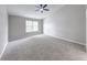 Large bedroom features neutral carpet, big window, and ceiling fan at 705 Treyburn Lakes Way, Indianapolis, IN 46239