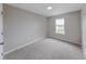 Bedroom with neutral walls, carpet, and a window overlooking the neighborhood at 705 Treyburn Lakes Way, Indianapolis, IN 46239
