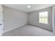 Sunlit bedroom with a window showcasing the outdoor view and neutral-toned walls at 705 Treyburn Lakes Way, Indianapolis, IN 46239