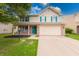 Charming two-story home featuring an attached two-car garage, a lawn, and decorative teal shutters and front door at 705 Treyburn Lakes Way, Indianapolis, IN 46239