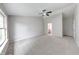 Spacious bedroom with neutral carpet, large window, and ceiling fan at 705 Treyburn Lakes Way, Indianapolis, IN 46239
