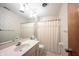 Bathroom featuring a single sink, and tub with shower curtain, and patterned wallpaper at 7115 Fremont Ct, Indianapolis, IN 46256