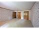 Spacious bedroom featuring floral wallpaper, neutral carpeting, and ample closet space for storage at 7115 Fremont Ct, Indianapolis, IN 46256