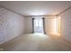 Bright bedroom with neutral carpeting, floral wallpaper, and a window for natural light at 7115 Fremont Ct, Indianapolis, IN 46256