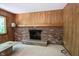 Cozy living room featuring a brick fireplace, wood-paneled walls, and neutral carpet at 7115 Fremont Ct, Indianapolis, IN 46256