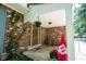 Inviting covered front porch featuring brick accents, a charming wooden door, and potted flowers at 7115 Fremont Ct, Indianapolis, IN 46256