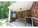 Welcoming covered front porch with brick detailing, wooden door, and charming potted plants at 7115 Fremont Ct, Indianapolis, IN 46256