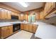 Well-equipped kitchen featuring wood cabinets, laminate countertops, and modern appliances at 7115 Fremont Ct, Indianapolis, IN 46256
