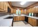 Efficient kitchen layout with appliances, laminate countertops, and warm wood cabinets at 7115 Fremont Ct, Indianapolis, IN 46256