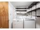 Laundry room featuring modern washer and dryer units, shelving, and storage space at 7115 Fremont Ct, Indianapolis, IN 46256