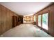Spacious living room with wood paneled walls, built-in shelving and access to the outdoor deck at 7115 Fremont Ct, Indianapolis, IN 46256