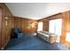 Inviting living room featuring wood paneling, plush blue carpeting, and comfortable seating for relaxing and entertaining at 7115 Fremont Ct, Indianapolis, IN 46256
