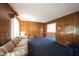 Cozy living room with wood paneling and plush blue carpet, providing a comfortable and inviting atmosphere at 7115 Fremont Ct, Indianapolis, IN 46256