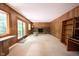 Spacious living room with wood-paneled walls, brick fireplace, and sliding glass doors to the outside at 7115 Fremont Ct, Indianapolis, IN 46256