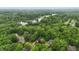 Aerial view of a lush, green neighborhood with large trees, houses, and a lake in the distance at 7138 Nile Ridge Ct, Indianapolis, IN 46236