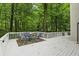 Outdoor deck featuring cozy seating, a vibrant rug, and views of the peaceful, lush backyard at 7138 Nile Ridge Ct, Indianapolis, IN 46236