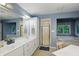 A serene bathroom showcasing a double sink vanity, walk-in shower and large tub at 7138 Nile Ridge Ct, Indianapolis, IN 46236