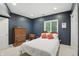 This bedroom offers a simple design with hardwood furniture, a window, and lighting at 7138 Nile Ridge Ct, Indianapolis, IN 46236