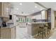 Bright open-concept kitchen with an island, breakfast bar, neutral cabinets, and a seamless flow into the dining area at 7138 Nile Ridge Ct, Indianapolis, IN 46236