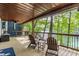 Covered deck with two Adirondack chairs overlooking a lake surrounded by trees at 7207 Grouper Dr, Nineveh, IN 46164