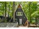 A-frame home with white door, dark siding, and surrounded by lush trees at 7207 Grouper Dr, Nineveh, IN 46164