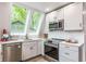 Updated kitchen features stainless steel appliances, white cabinets, countertop, and large window at 7207 Grouper Dr, Nineveh, IN 46164