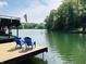 Dock view with Adirondack chairs with a peaceful lake and green trees at 7207 Grouper Dr, Nineveh, IN 46164
