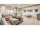 Inviting living room with a cozy sectional sofa, light wood floors, and a sliding glass door to the outdoor scenery at 7207 Grouper Dr, Nineveh, IN 46164