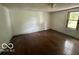 A bedroom has hardwood floors, a window with a view, and potential for updates at 721 Haugh St, Indianapolis, IN 46222