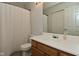 Clean bathroom with a wide mirror, wood vanity, and shower with white curtain at 7529 Oceanline Dr, Indianapolis, IN 46214