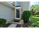 Inviting entryway with sidelight window, brick accents, and lush landscaping enhances this home's exterior at 7529 Oceanline Dr, Indianapolis, IN 46214