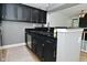 A well-appointed kitchen featuring dark cabinetry, modern countertops, stainless appliances, and wood-look flooring at 7529 Oceanline Dr, Indianapolis, IN 46214
