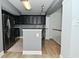 Contemporary kitchen featuring dark cabinetry, stainless steel appliances, and hardwood flooring at 7529 Oceanline Dr, Indianapolis, IN 46214