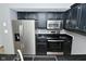 Kitchen featuring stainless steel appliances, dark cabinets, granite counters, and ample storage space at 7529 Oceanline Dr, Indianapolis, IN 46214