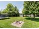 Lush green backyard featuring a trampoline, shed, playground set, and a fire pit at 7742 Bayridge Dr, Indianapolis, IN 46236