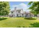 Large backyard with lush green grass, a fire pit, patio furniture, and a trampoline at 7742 Bayridge Dr, Indianapolis, IN 46236