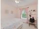 Bright bedroom with pink walls, colorful curtains, white desk and chair, and a bed with a rainbow-themed bedspread at 7742 Bayridge Dr, Indianapolis, IN 46236