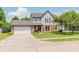 Inviting two-story residence with brick detailing, a two-car garage, and a lovely, green front lawn at 7742 Bayridge Dr, Indianapolis, IN 46236