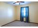 Bedroom with neutral carpet, light walls, ceiling fan, and window with blue chevron curtains at 8370 State Road 236, North Salem, IN 46165