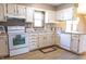 Well lit kitchen with white cabinets, range, dishwasher, sink, and laminate flooring at 8370 State Road 236, North Salem, IN 46165