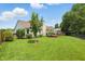 Expansive backyard with a well-manicured lawn, mature trees, and a wood deck at 863 Lionshead Ln, Greenwood, IN 46143