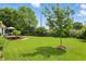 Large backyard with manicured lawn, mature trees, and a charming deck area for outdoor enjoyment at 863 Lionshead Ln, Greenwood, IN 46143