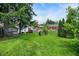 Lush backyard showcasing mature trees, a hammock, and a fire pit for outdoor gatherings at 907 N Arlington Ave, Indianapolis, IN 46219
