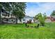 Large, green backyard featuring a cozy fire pit area, a hammock, and a well-maintained lawn at 907 N Arlington Ave, Indianapolis, IN 46219
