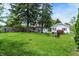 Spacious backyard with mature trees, a hammock, fire pit, and a well-manicured lawn at 907 N Arlington Ave, Indianapolis, IN 46219