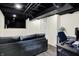 Finished basement with a large television, comfortable couch and dedicated workspace with modern monitors and a desk at 907 N Arlington Ave, Indianapolis, IN 46219
