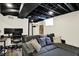 Finished basement featuring dark ceiling, gray sofa, wood flooring and office space at 907 N Arlington Ave, Indianapolis, IN 46219