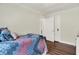 Comfortable bedroom features wood floor, door, closet, and bed with colorful quilt at 907 N Arlington Ave, Indianapolis, IN 46219